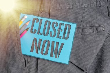 Conceptual hand writing showing Closed Now. Business photo showcasing of a business having ceased trading especially for a short period Writing equipment and blue note paper in pocket of trousers. clipart