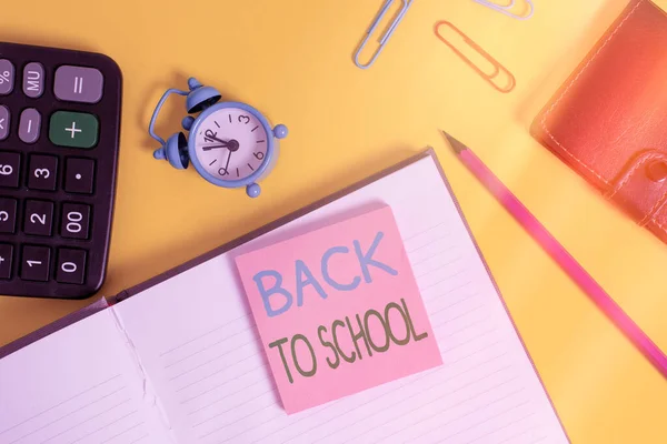 Signo de texto que muestra Volver a la escuela. Foto conceptual es el período relacionado con el comienzo de un nuevo año escolar Calculadora de la billetera del cuaderno clips lápiz nota alarma reloj color fondo . —  Fotos de Stock