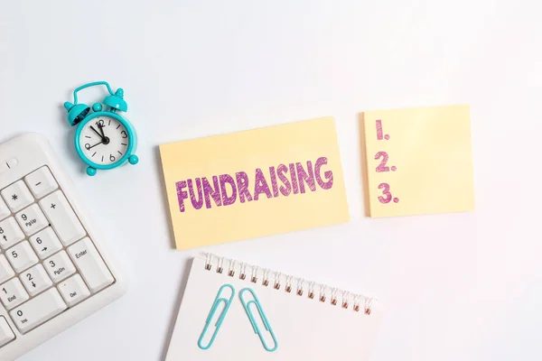 Handwriting text Fundraising. Concept meaning act of collecting or producing money for a particular purpose Blank paper with copy space on the table with clock and pc keyboard. — Stock Photo, Image