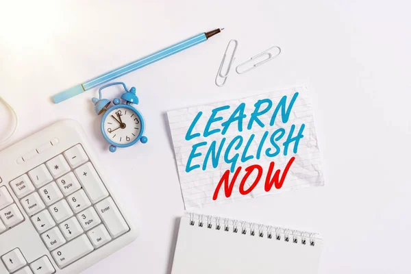 Texto para escribir palabras Aprende inglés ahora. Concepto de negocio para obtener o adquirir conocimientos y habilidades del idioma inglés Copiar el espacio en papel de nota vacío con reloj y lápiz sobre la mesa . — Foto de Stock