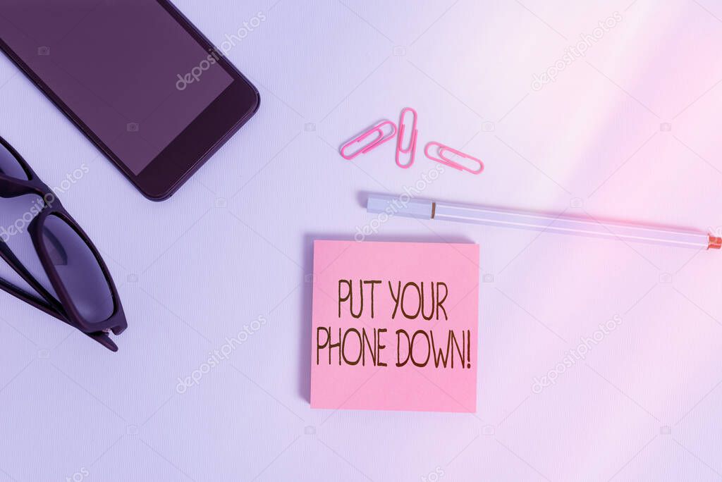 Writing note showing Put Your Phone Down. Business photo showcasing end telephone connection saying goodbye caller Eyeglasses colored sticky note smartphone cell pen pastel background.