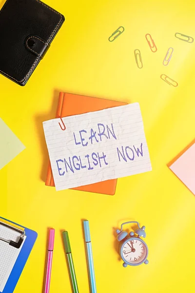 Writing note showing Learn English Now. Business photo showcasing gain or acquire knowledge and skill of english language Flat lay above empty paper with pencils and paper clips. — Stock Photo, Image