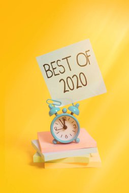 2020 'nin en iyi el yazısı metni. Kavram, 2020 'de büyük ve olağanüstü şeyler ve olaylar meydana geldi. Metal alarm saati boş. Not defterleri renkli arka planda..