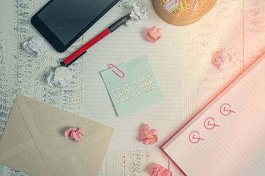 Kişisel Bakım 'ı gösteren kavramsal el yazısı. İş fotoğrafında, bir şeyi geliştirmek için harekete geçme pratiği gösteriliyor. Smartphone tablosu ataçları kalem kâğıdı topları, ahşap zarf..