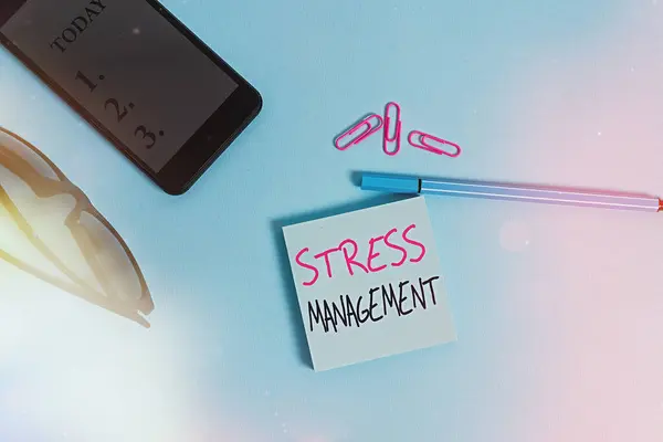 ワードライティングテキストストレス管理。ストレスを抑える方法とその効果を学ぶ方法のビジネスコンセプト眼鏡の色付き付箋スマートフォンのクリップペンパステル背景. — ストック写真