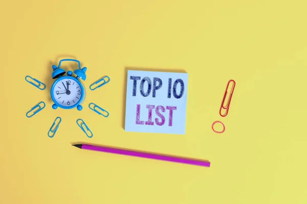 Writing note showing Top 10 List. Business photo showcasing the ten most important or successful items in a particular list Alarm clock wakeup clips rubber band pencil notepad colored background. — Stock Photo, Image