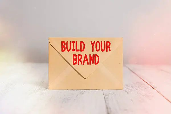 문자를 쓰는 것은 당신의 브랜드를 만든다. 개념은 광고 캠페인을 이용하여 브랜드의 공정성을 강화하는 것을 의미 합니다. 직사각 형의 색 봉투를 폐쇄하고 오래 된 나무로 된 빈티지 배경을. — 스톡 사진