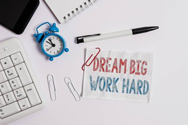Kavramsal el yazısı Dream Big Work Hard 'ı gösteriyor. İş fotoğrafı metni Kendine inan ve hayalleri ve hedefleri takip et Bilgisayar cep telefonu saat kalemi ve kağıt üzerinde düz yatıyordu.