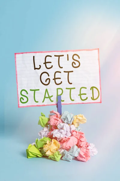 Conceptual hand writing showing Let S Get Started. Business photo showcasing encouraging someone to begin doing something Reminder pile colored crumpled paper clothespin wooden space. — Stock Photo, Image