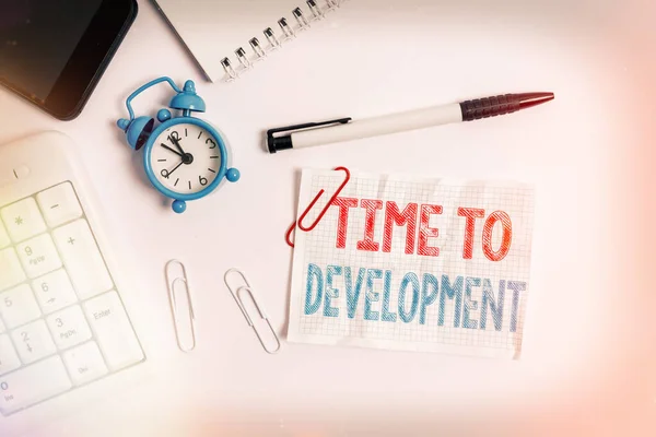 Conceptual hand writing showing Time To Development. Business photo text a length of time during which a company grows or develop Flat lay above computer mobile phone clock pencil and note paper.