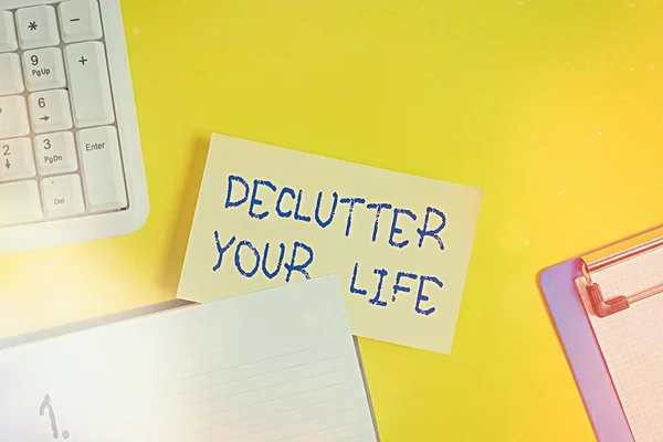 Γράφοντας σημείωμα που δείχνει Declutter τη ζωή σας. Επαγγελματική φωτογραφία προβολής Για να εξαλείψει ξένα πράγματα ή πληροφορίες στη ζωή Κενό πορτοκαλί χαρτί με αντίγραφο χώρο στο κίτρινο τραπέζι. — Φωτογραφία Αρχείου