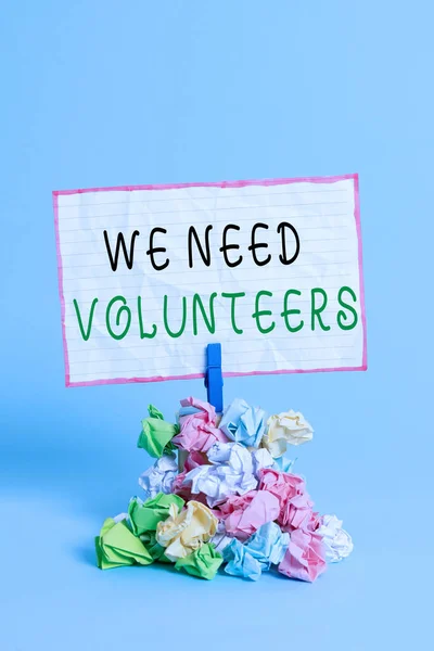 Conceptual hand writing showing We Need Volunteers. Business photo showcasing someone who does work without being paid for it Reminder pile colored crumpled paper clothespin wooden space. — Stock Photo, Image