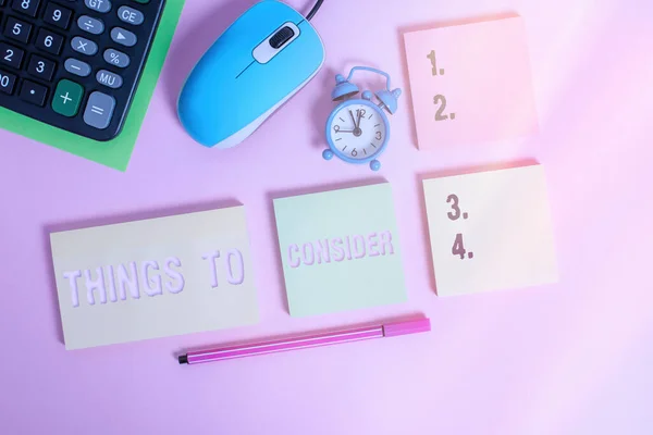 Texto de escritura a mano Cosas a considerar. Concepto que significa pensar cuidadosamente, especialmente en la toma de decisiones Bloc de notas de alarma del ratón reloj calculadora hoja marcador de color de fondo . — Foto de Stock