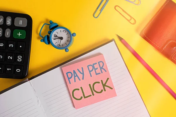 Tekstbord met Pay Per Click. Conceptuele foto internet marketing waarin de betaling is gebaseerd op clickthroughs Notebook portemonnee rekenmachine clips potlood notitie wekker kleur achtergrond. — Stockfoto