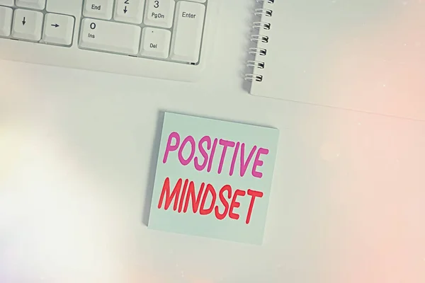 Handwriting text writing Positive Mindset. Concept meaning mental attitude in wich you expect favorable results Empty note paper on the white background by the pc keyboard with copy space.