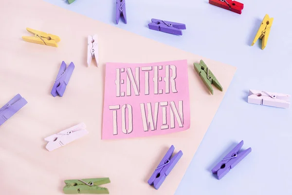 Schrijfbriefje met Enter To Win. Zakelijke foto presentatie ruilen iets waardevols voor prijs kans winnende prijs Gekleurde wasknijper papier herinnering met geel blauwe achtergrond. — Stockfoto