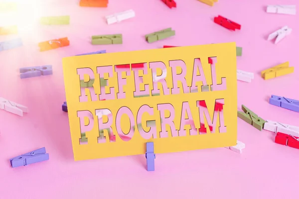 Text sign showing Referral Program. Conceptual photo employees are rewarded for introducing suitable recruits Colored clothespin papers empty reminder pink floor background office pin.