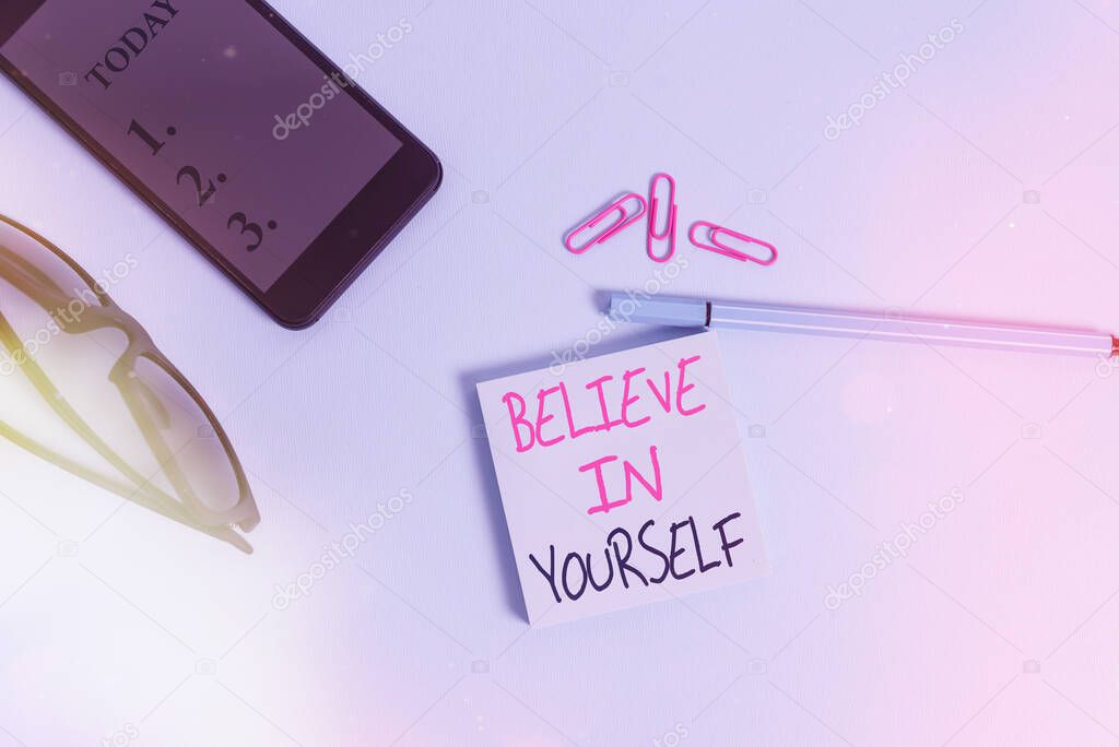 Word writing text Believe In Yourself. Business concept for common piece of advice that you can do everything Eyeglasses colored sticky note smartphone cell clips pen pastel background.