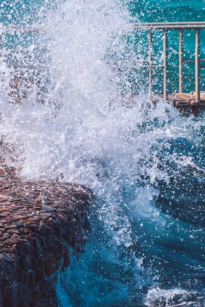 Photo of beautiful clear turquoise sea ocean water surface with ripples and bright splash on stone sea cape background, zdjęcie poziome — Zdjęcie stockowe