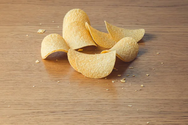 Heerlijke aardappelchips, tot op houten tafel achtergrond — Stockfoto