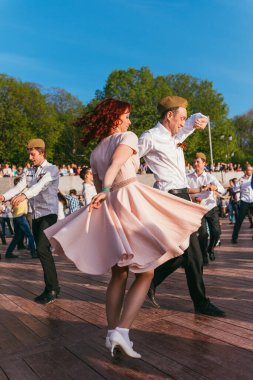 Moskova, Rusya-09 Mayıs 2015: İnsanlar güneşli bir günde Pushkinskaya seti üzerindeki parkta açık havada dans ediyorlar.
