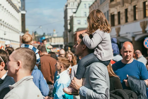 MOSCÚ, RUSIA-09 DE MAYO DE 2015: La gente celebra el Día de la Victoria el 9 de mayo en Bolshoy Moskvoretskiy Most. Una niña se sienta en el cuello de los padres. Mucha gente con las cintas de San Jorge — Foto de Stock