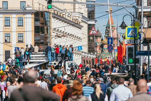 МОСКВА, Россия-9 мая 2015 г.: 9 мая в Большом Москворецком мосту люди празднуют День Победы. Люди забираются на белый грузовик, чтобы увидеть парад на фоне Кремля. Много людей с — стоковое фото