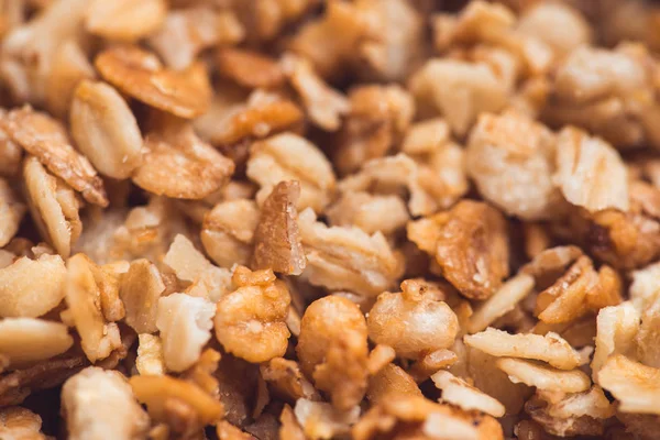 Useful and tasty muesli with nuts, rasins and flakes. Selective focus macro shot with very shallow depth of field. Healthy and vegetarian lifestyle — Stock Photo, Image
