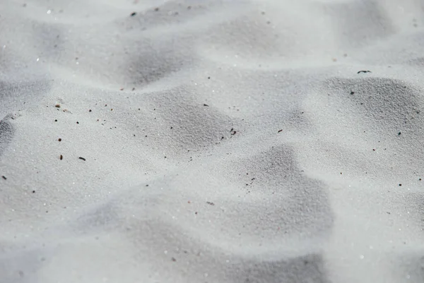 Крупный план белого морского песка на пустынном пляже. Концепция праздников и ярких солнечных дней. Выборочный фокус макросъемки с мелким DOF — стоковое фото