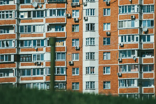 Σύγχρονο νέο, multi-family κτίριο κατοικιών με πράσινο γρασίδι στο προσκήνιο. την έννοια της νέας ζωής και της μετακόμισης. Επιλεκτική μακροεντολή εστίασης με ρηχό Dof — Φωτογραφία Αρχείου