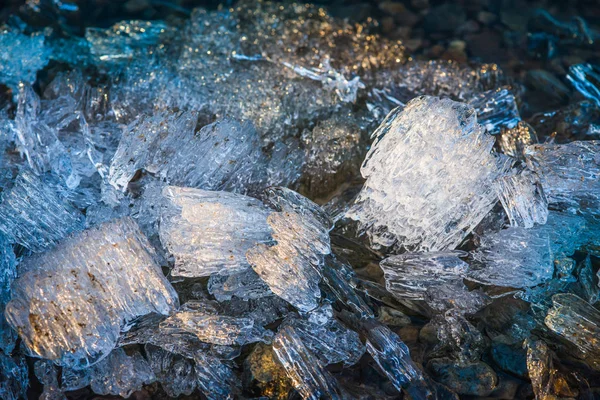 Des morceaux de glace fondante sous le soleil du printemps sur la rive de la rivière. Mise au point sélective macro prise avec DOF peu profond — Photo