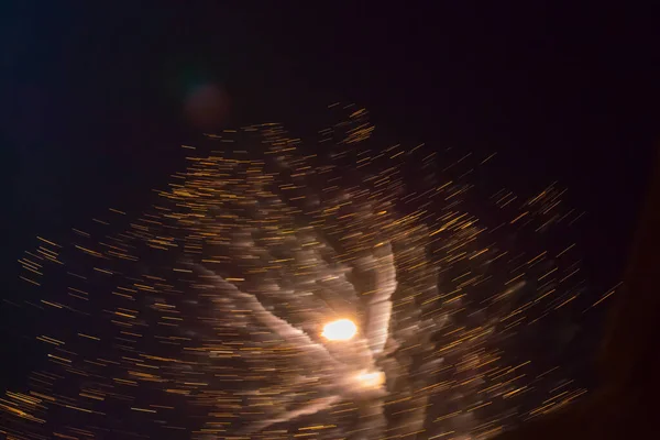 Colori festivi lucenti e lampi di fuochi d'artificio sul cielo nero. Sfocato dal movimento creativo movimento sfocato — Foto Stock