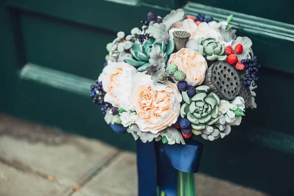 Χειροποίητα λουλούδια από ιαπωνικό πολυμερές πηλό. Μοιάζουν με αληθινή γαμήλια ανθοδέσμη. Στο φόντο μιας πράσινης ξύλινης πόρτας — Φωτογραφία Αρχείου