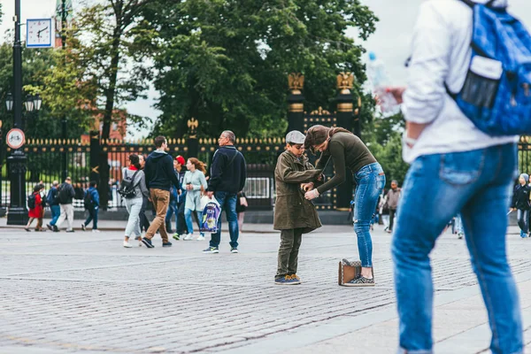 Moscú, Rusia - 7 de julio de 2017. Una multitud de turistas cerca del jardín Alexander y la plaza roja. El objeto principal es una madre que abrocha el abrigo de sus hijos — Foto de Stock