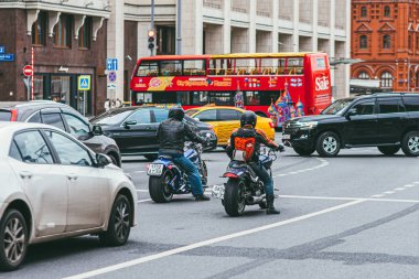 Moskova, Rusya - 7 Temmuz 2017. Siyah deri takım elbiseli iki motosikletli Harley Davidson motosikletinin üzerinde oturur ve yol boyunca mashinami ile gezer.