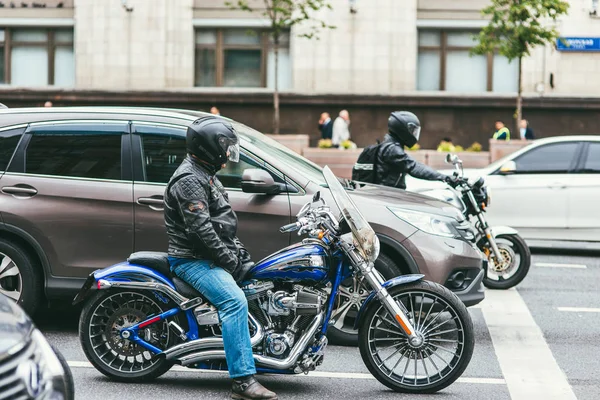 Moskau, russland - 7. Juli 2017. 2 Motorradfahrer in schwarzen Lederanzügen sitzen auf Harley-Davidson-Motorrädern und fahren mit Mashinami die Fahrbahn entlang — Stockfoto