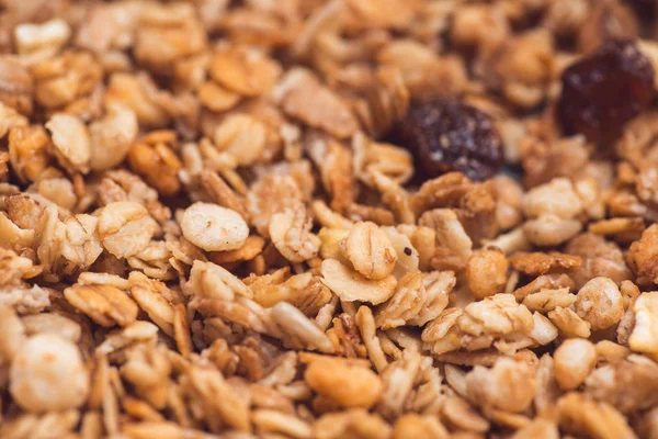 Useful and tasty muesli with nuts, rasins and flakes. Selective focus macro shot with very shallow depth of field. Healthy and vegetarian lifestyle — Stock Photo, Image