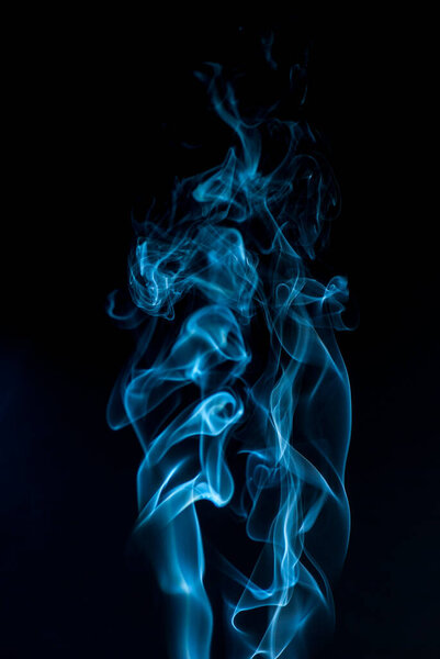 Beautiful smoke on the black background - macro photo. The concept of incense in the apartment. Isolated on black background overlay for your needs.