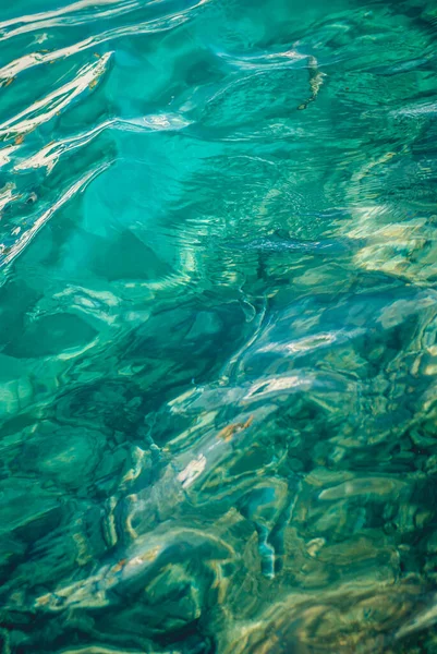 透き通ったターコイズブルーの海の水面で波が低く — ストック写真