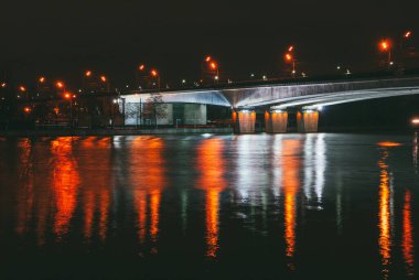 Gece manzarası, köprünün altındaki nehir manzaralı fenerlerin ışığında. kenar geniş görünüm