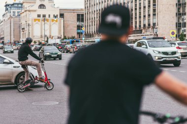 Moskova, Rusya - 7 Temmuz 2017: Bisikletli genç adam dolu bir caddeyi geçiyor