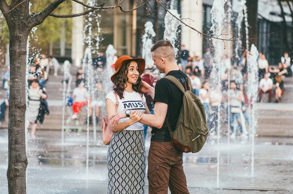 Москва, Россия - 1 мая 2018 года. Активные люди в городе. Молодой человек, женщина носят юбку и других людей, наслаждающихся в городском фонтане — стоковое фото