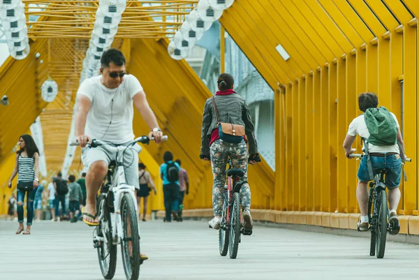 Москва, Россия - 1 июня 2014 года: Молодая пара и мужчина на велосипедах пересекают пешеходный мост Богдана Хмельницкого — стоковое фото