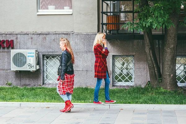 Moscou, Rússia - 7 de julho de 2017: 2 mulheres de roupas vermelhas descem a rua em Moscou. Uma mulher está ao telefone. — Fotografia de Stock