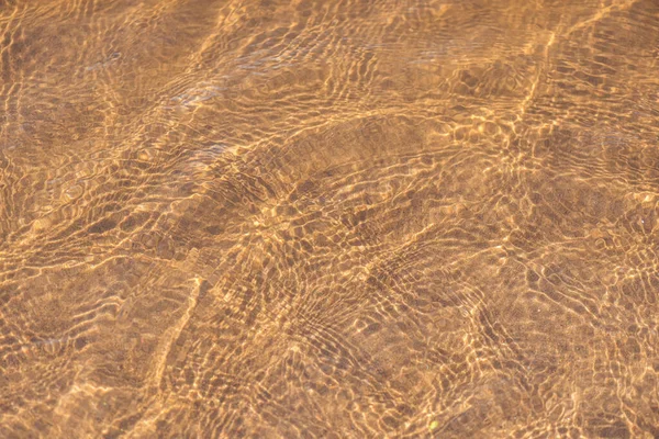 Золотой песок пляжа под чистой водой моря — стоковое фото
