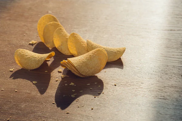 Läckra chips, om på trä bords bakgrund — Stockfoto