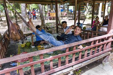 Cambodian guys resting under a gazebo in Phnom kulen national park, Cambodia clipart
