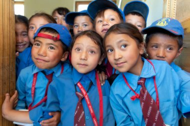 Sumur, India - August 20, 2015: Curious students look out of the classroom at Lamdon school. The Lamdon School is a charitable organization with the objective to enable education for poor children