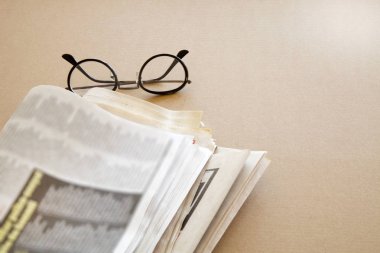 Kahverengi zemin üzerine gözlük ile gazete