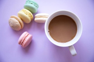 Macaron üzerinde pembe bir arka plan ile kahve fincanı